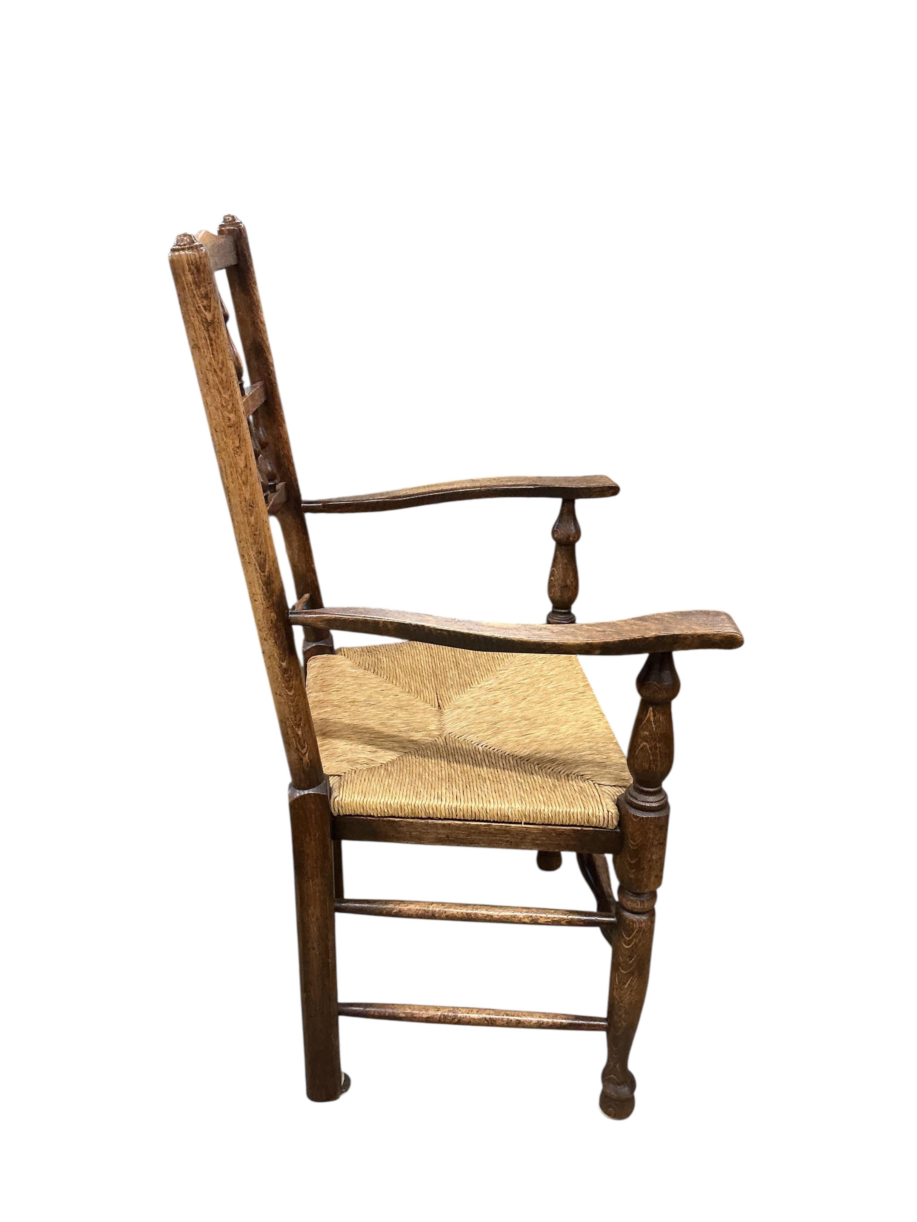 A set of ten Lancashire style ash and beech rush seat spindle back dining chairs, two with arms